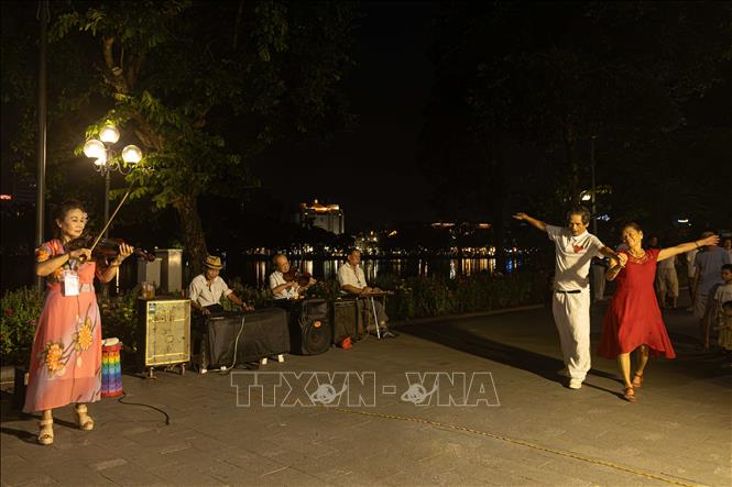 Người dân và du khách hào hứng tham gia hoạt động khiêu vũ, giao lưu âm nhạc bên không gian đi bộ Hồ Hoàn Kiếm. Các nhóm nghệ sĩ tự do và câu lạc bộ nghệ thuật cộng đồng thường xuyên duy trì biểu diễn vào cuối tuần, góp phần nâng cao đời sống tinh thần và tạo nét đẹp văn hóa đặc trưng cho kinh tế đêm Hà Nội. Ảnh: Tiến Long/TTXVN phát
