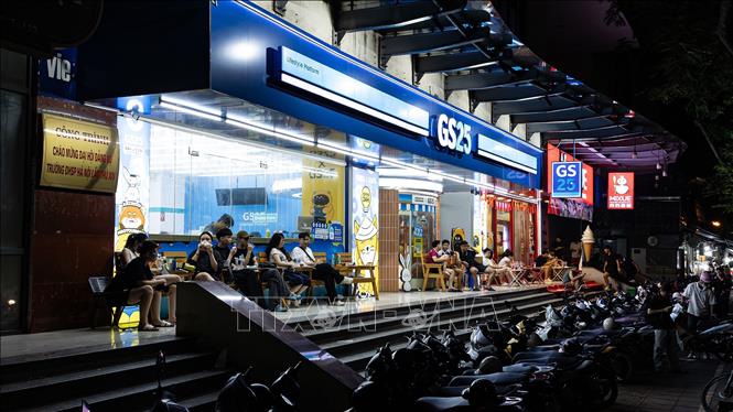 Các cửa hàng tiện lợi mở cửa 24/7 luôn đỏ đèn, thu hút đông đảo giới trẻ và sinh viên tập trung trò chuyện, ăn uống về đêm. Sự bùng nổ của các chuỗi bán lẻ 24/7 không chỉ đáp ứng nhu cầu sinh hoạt xuyên đêm của người dân đô thị hiện đại mà còn là mảnh ghép hạ tầng dịch vụ quan trọng, thúc đẩy hệ sinh thái kinh tế đêm phát triển đa dạng và năng động tại Hà Nội. Ảnh: Tiến Long/TTXVN phát