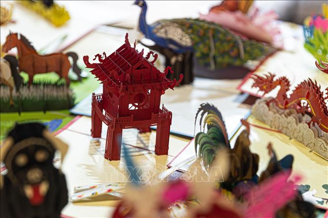 Thiệp giấy nổi 3D tạo hình Khuê Văn các cùng các biểu tượng dân gian Việt Nam bày bán tại tuyến phố đi bộ đêm. Việc đa dạng hóa các mặt hàng quà tặng, đồ thủ công mỹ nghệ tại chợ đêm đáp ứng nhu cầu mua sắm và quảng bá hình ảnh di sản Hà Nội tới du khách quốc tế. Ảnh: Tiến Long/TTXVN phát
