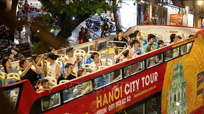 Đông đảo du khách trong và ngoài nước thích thú ngắm nhìn toàn cảnh không gian Hà Nội về đêm từ không gian mở trên tầng 2 của xe bus du lịch (Hanoi City Tour). Việc đưa vào vận hành và đẩy mạnh các tour ngắm cảnh đêm (Night Tour) bằng phương tiện hiện đại không chỉ làm đa dạng hóa các lựa chọn trải nghiệm cho du khách khi thành phố lên đèn, mà còn đóng vai trò như một 