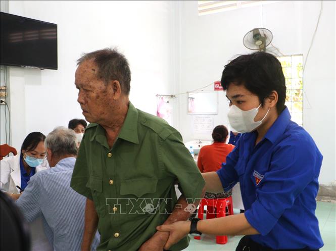 Đoàn viên hỗ trợ người có công khám bệnh miễn phí nhân dịp 27/7. Ảnh: Lê Thúy Hằng – TTXVN
