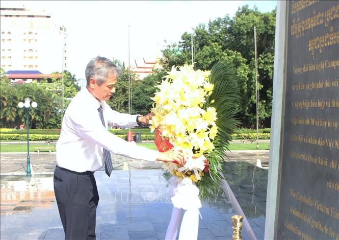 Đại sứ Nguyễn Minh Vũ chỉnh vòng hoa tại Đài Hữu nghị Campuchia – Việt Nam ở thủ đô Phnom Penh. Ảnh: Minh Hưng – PV TTXVN tại Campuchia
