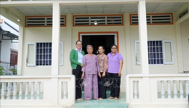 Cán bộ xã Giồng Riềng chụp ảnh cùng bà Lê Thị Thiêu, mẹ của Liệt sĩ Phạm Thanh Lân (Liệt sĩ Lân hy sinh tại chiến trường Campuchia năm 1983). Ảnh: Văn Sĩ - TTXVN                               
