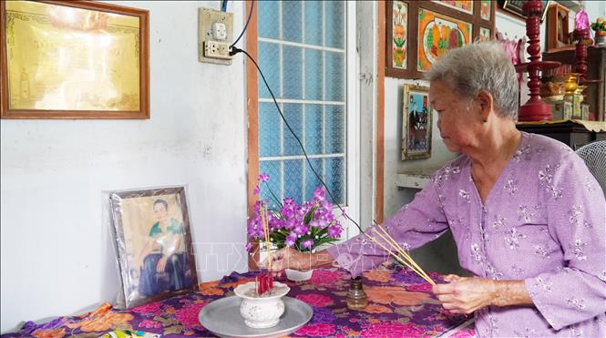 Bà Lê Thị Thiêu thắp hương cho con trai cả là Liệt sĩ Phạm Thanh Lân (Liệt sĩ Lân hy sinh tại chiến trường Campuchia năm 1983). Ảnh: Văn Sĩ - TTXVN                               