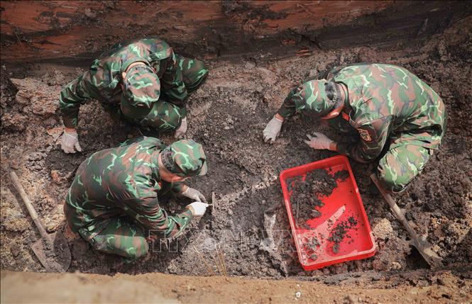 Quy trình sau khi khai quật hài cốt liệt sĩ được thực hiện cẩn thận, tỉ mỉ, khoa học, đảm bảo an toàn. Ảnh: Phan Phương - TTXVN