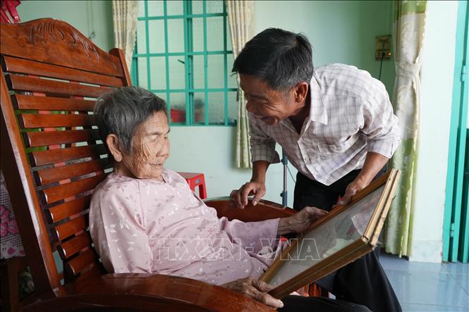 Mẹ Việt Nam Anh hùng Hồ Thị Vàng (90 tuổi, ngụ phường Tân Triều, thành phố Đồng Nai) xem tấm Bằng Tổ quốc ghi công của liệt sĩ Nguyễn Văn Dậy hiện vẫn chưa tìm được nơi an nghỉ. Ảnh: Lê Xuân - TTXVN