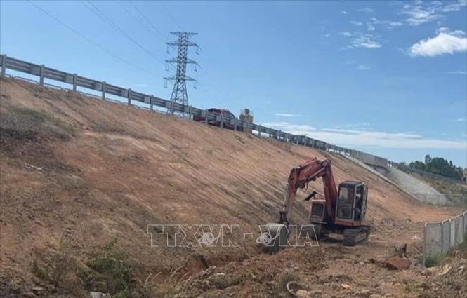 Nhà thầu thi công tiến hành thu dọn đất đá sau khi thi công dự án đường gom Dự án thành phần đoạn Chí Thạnh - Vân Phong. Ảnh: TTXVN phát