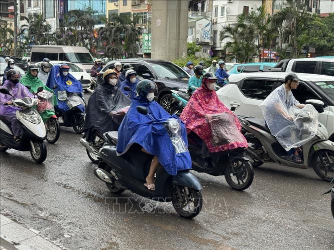 Mặt đường trơn ướt, lưu lượng phương tiện tăng cao khiến dòng xe di chuyển chậm. Ảnh: Quốc Lũy - TTXVN