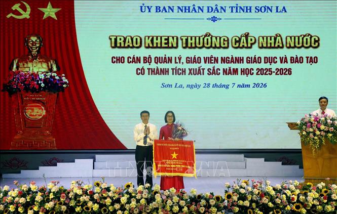 Giám đốc Sở Giáo dục và Đào tạo tỉnh Sơn La Nguyễn Văn Chiến chuyển trao Cờ thi đua của Chính phủ cho đại diện Trường Tiểu học và Trung học cơ sở Tây Tiến (phường Mộc Châu, tỉnh Sơn La). Ảnh: Quang Quyết - TTXVN