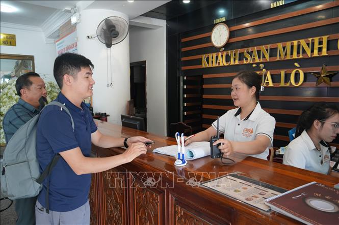 Du khách làm thủ tục nhận phòng tại Khách sạn Minh Châu, phường Cửa Lò. Ảnh: Bích Huệ - TTXVN