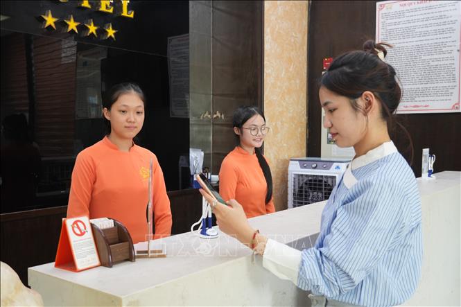Du khách thanh toán tiền phòng qua ứng dụng quét QR tại khách sạn. Ảnh: Bích Huệ - TTXVN