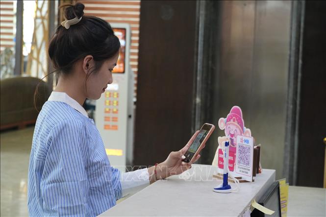 Du khách thanh toán tiền phòng qua ứng dụng quét QR tại khách sạn. Ảnh: Bích Huệ - TTXVN