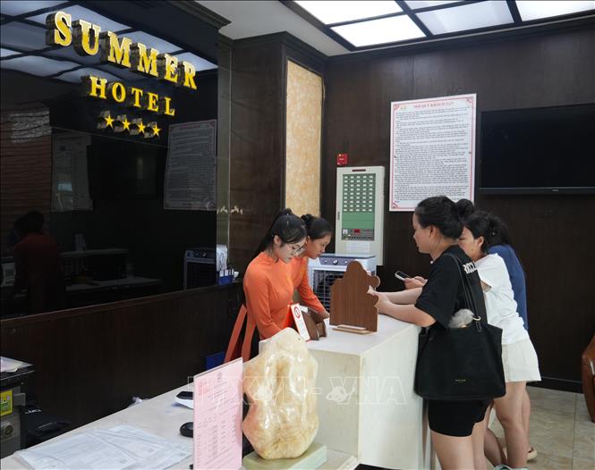Du khách làm thủ tục nhận phòng tại khách sạn Summer, phường Cửa Lò (Nghệ An). Ảnh: Bích Huệ - TTXVN