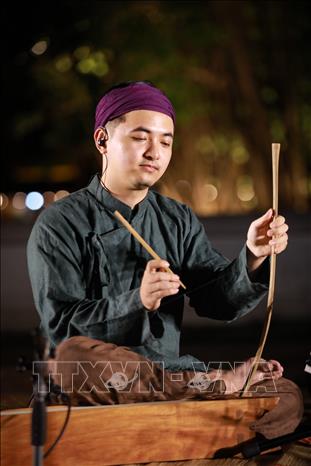 Nghệ nhân giới thiệu nhạc cụ đàn bầu trong nghệ thuật hát Xẩm, góp phần đưa di sản đến gần hơn với công chúng. Ảnh: Khánh Hoà - TTXVN