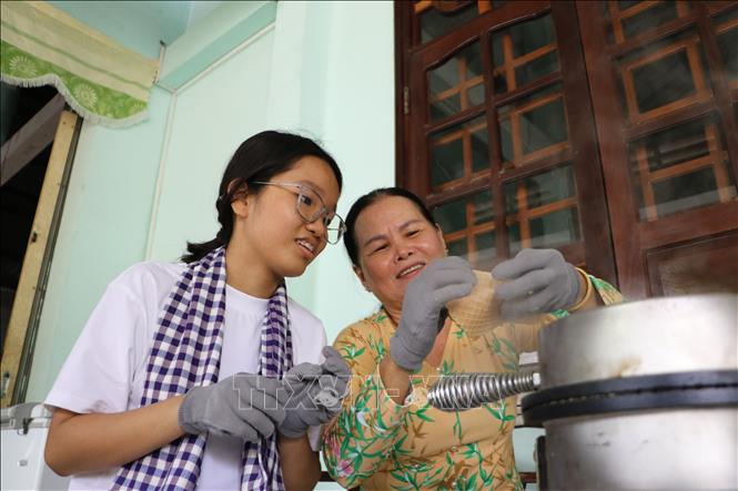 Du khách trải nghiệm làm bánh kẹp xoài tại Di tích Phủ thờ Thư Ngọc Hầu (xã Mỹ Thọ). Ảnh: Hồng Thái - TTXVN