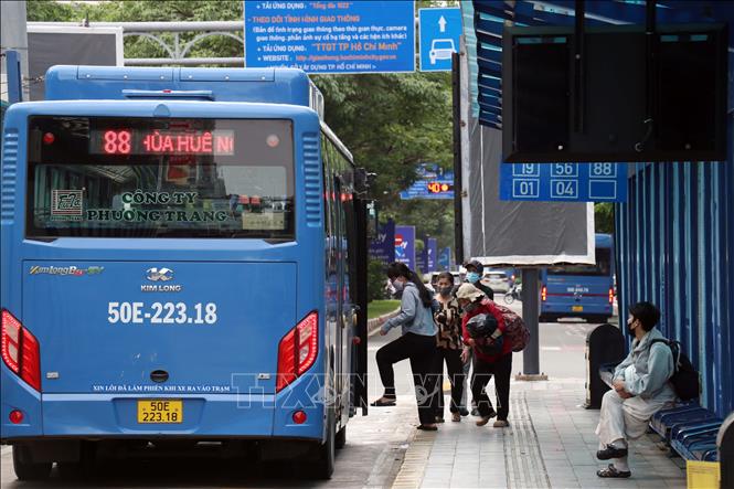 Hành khách lên xe buýt tại trạm trung chuyển trên đường Hàm Nghi sáng 30/7/2026. Ảnh: Tiến Lực - TTXVN