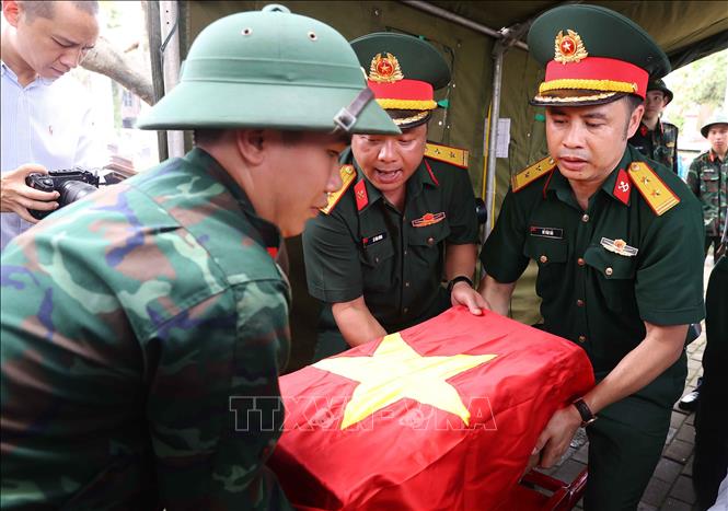 Thực hiện nghi thức phủ Quốc kỳ trang trọng, tri ân Anh hùng liệt sĩ đã hy sinh vì độc lập, tự do của Tổ quốc. Ảnh: Văn Điệp – TTXVN