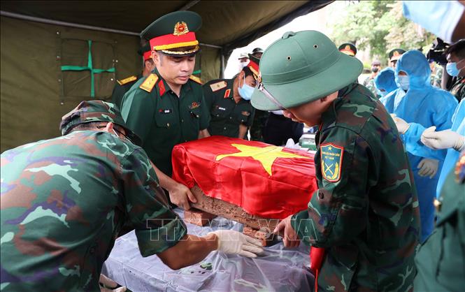 Trang trọng thực hiện quy trình khai quật, đưa hài cốt liệt sĩ chưa xác định danh tính về khu vực lấy mẫu sinh phẩm sĩ tại Nghĩa trang liệt sĩ Ngọc Hồi (xã Thanh Trì). Ảnh: Văn Điệp – TTXVN