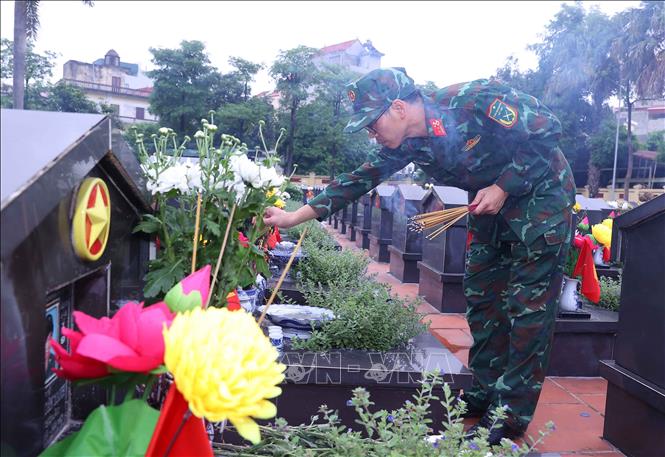 Thắp hương trên phần mộ liệt sĩ tại Nghĩa trang liệt sĩ Ngọc Hồi (xã Thanh Trì). Ảnh: Văn Điệp – TTXVN