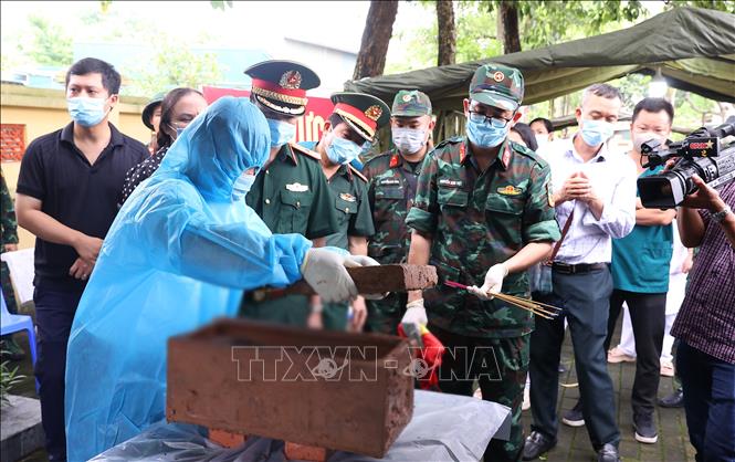 Hài cốt liệt sĩ chưa xác định danh tính về khu vực lấy mẫu sinh phẩm tại Nghĩa trang liệt sĩ Ngọc Hồi (xã Thanh Trì). Ảnh: Văn Điệp – TTXVN