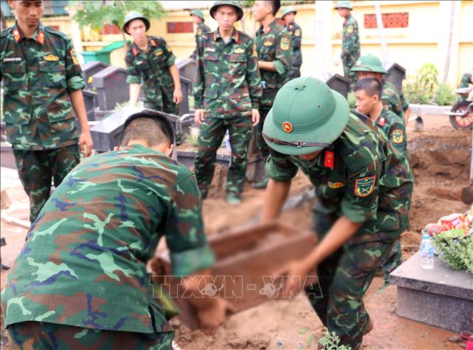Thực hiện quy trình khai quật, đưa hài cốt liệt sĩ chưa xác định danh tính về khu vực lấy mẫu sinh phẩm tại Nghĩa trang liệt sĩ Ngọc Hồi (xã Thanh Trì). Ảnh: Văn Điệp – TTXVN