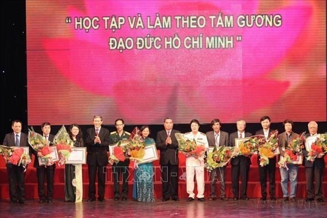 Thường trực Ban Bí thư Lê Hồng Anh và Trưởng Ban Tuyên giáo Trung ương Đinh Thế Huynh trao giải cho các tác giả đoạt giải A tại Lễ trao giải sáng tác, quảng bá tác phẩm văn học, nghệ thuật, báo chí về chủ đề “Học tập và làm việc theo tấm gương đạo đức Hồ Chí Minh” đợt 1 (2011-2013). Ảnh: Lâm Khánh - TTXVN