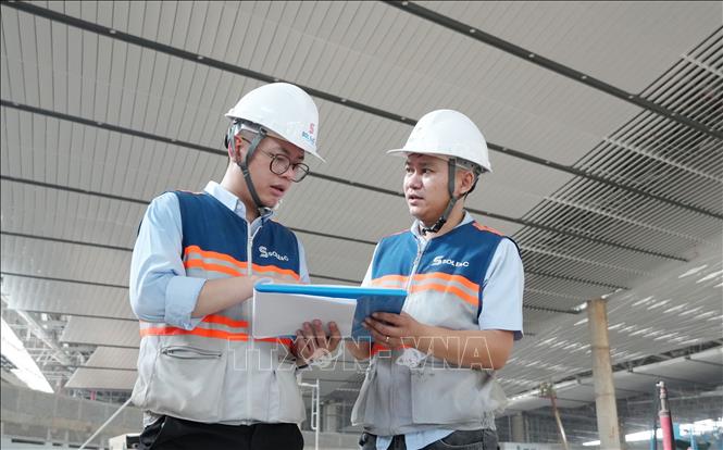 Kỹ sư trao đổi về việc thi công mái nhà hành khách sân bay Long Thành. Ảnh: Công Phong - TTXVN