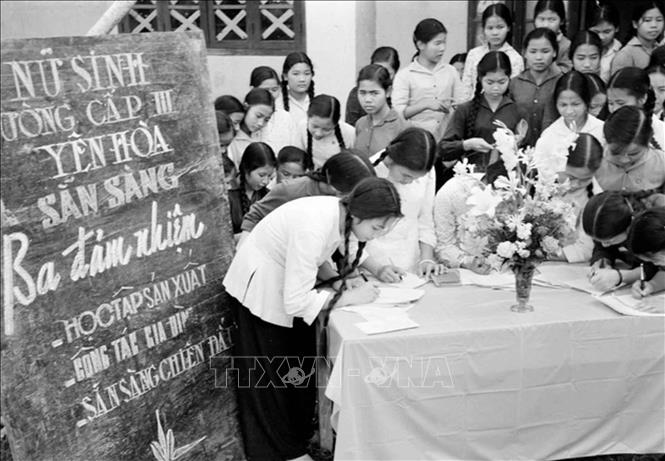 Ở miền Bắc, công tác tuyên giáo tập trung tuyên truyền, đẩy mạnh các phong trào thi đua yêu nước, như “Vì miền Nam ruột thịt”, “Thanh niên ba sẵn sàng”, “Phụ nữ ba đảm đang”, chi viện đắc lực sức người, sức của cho tiền tuyến lớn miền Nam. Trong ảnh: Đăng ký tham gia Phong trào Ba đảm nhiệm (sau chuyển thành phong trào “Phụ nữ ba đảm đang”) tại Trường cấp III Yên Hòa, Hà Nội. Ảnh: Thanh Tụng - TTXVN