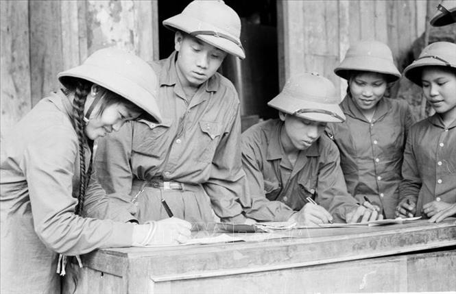 Giai đoạn 1961–1965, công tác tuyên giáo tập trung tuyên truyền, vận động, đẩy mạnh các phong trào thi đua yêu nước, phấn đấu hoàn thành vượt mức kế hoạch 5 năm lần thứ nhất. Nhiều điển hình xuất sắc xuất hiện trong phong trào quần chúng đã trở thành ngọn cờ cổ vũ phong trào thi đua. Trong ảnh: Thanh niên xung phong chống Mỹ, cứu nước Đội 32 ký Quyết tâm thư. Ảnh: Đức Liên - TTXVN