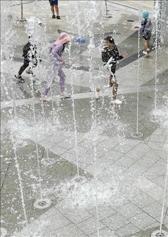 Em nhỏ làm mát dưới đài phun nước trong công viên ở Gumi, tỉnh Bắc Gyeongsang, Hàn Quốc ngày 28/7/2026. Ảnh: Yonhap/TTXVN phát