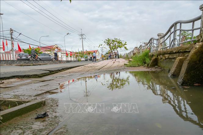 Đoạn kè kiên cố trước UBND xã Đại Hải, thành phố Cần Thơ bị sụp xuống so với mặt đường hơn nửa mét, xô lệch ra phía bờ sông. Ảnh: Thanh Liêm - TTXVN