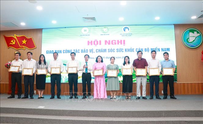 PGS.TS Lê Đình Thanh, Giám đốc Bệnh viện Thống Nhất trao bằng khen cho các cá nhân có thành tích xuất sắc trong công tác phối hợp, bảo vệ sức khỏe cán bộ. Ảnh: Huỳnh Anh - TTXVN