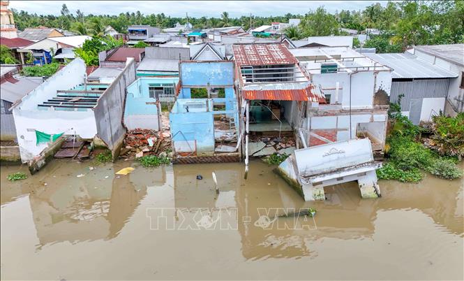 Những căn nhà bị sạt lở làm sụp hơn phân nửa xuống sông tại ấp Mang Cá, xã Đại Hải. Ảnh: Thanh Liêm - TTXVN