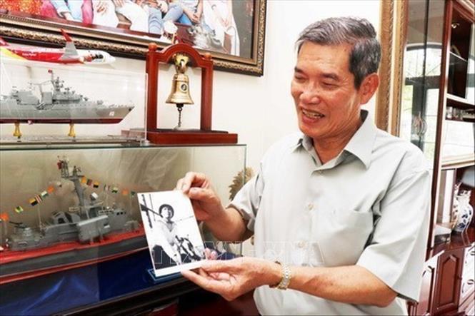 Nguyên Tư lệnh Hải quân, Phó Đô đốc Đỗ Xuân Công giới thiệu về bức ảnh do một phóng viên TTXVN chụp ông, chiến sỹ lái hạm thuyền trong trận chiến đấu ngày 5/8/1964 tại cảng Gianh, tỉnh Quảng Bình. Ảnh: Xuân Khu - TTXVN
