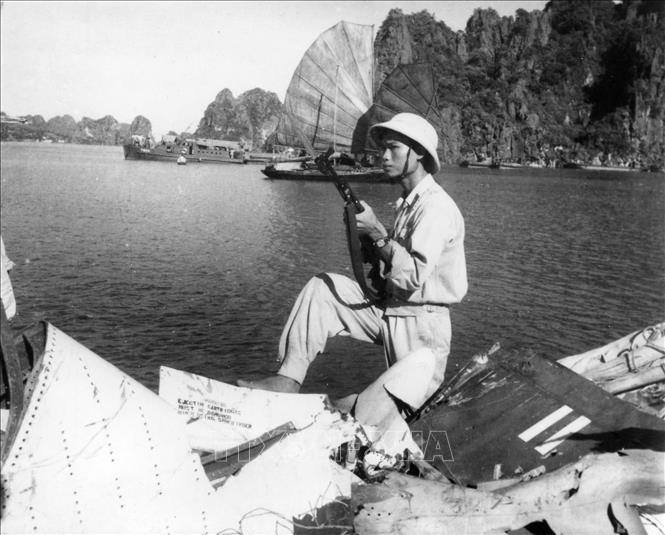 Bộ đội ta bên xác máy bay phản lực A4D, do Trung úy Hải quân Mỹ Everett Alvarez lái, bị bắn hạ tại thị xã Hòn Gai (Quảng Ninh) ngày 5/8/1964. Ảnh: TTXVN