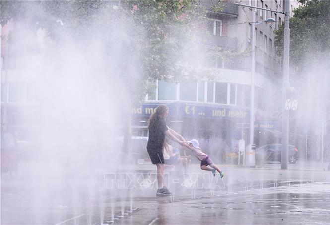 Người dân tránh nóng bên đài phun nước ở Vienna, Áo. Ảnh: THX/TTXVN phát