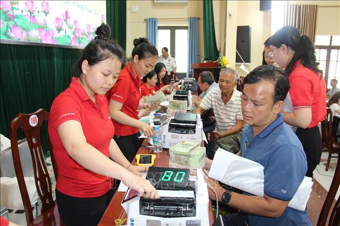 Người dân nhận tiền bồi thường giải phóng mặt bằng Cảng hàng không quốc tế Gia Bình. Ảnh: Thanh Thương- TTXVN