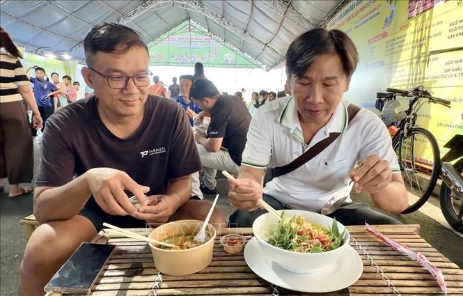 Du khách hào hứng thưởng thức bún kèn Hà Tiên món ăn mang đậm hương vị biển cả của vùng đất Hà Tiên, An Giang. Ảnh: Thanh Sang - TTXVN