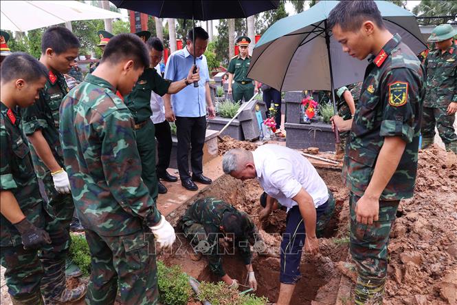 Thực hiện quy trình khai quật, đưa hài cốt liệt sĩ chưa xác định danh tính về khu vực lấy mẫu sinh phẩm tại Nghĩa trang liệt sĩ Nhổn (phường Tây Tựu). Ảnh: Văn Điệp – TTXVN