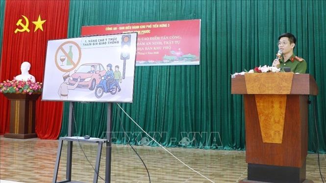Cán bộ công an phường Bình Phước tuyên truyền đảm bảo trật tự an toàn giao thông tại khu phố Tiến Hưng. Ảnh: Nhật Bình – TTXVN
