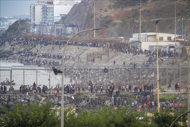 Người di cư tìm cách vào Ceuta bằng cách bơi qua biển hoặc trèo qua tuyến đê chắn sóng dọc bờ biển Fnideq, thị trấn phía bắc Maroc. Ảnh: AA/TTXVN phát