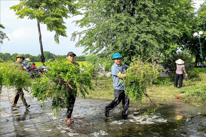 Người dân thôn Giao Tác tham gia chỉnh trang cảnh quan, vệ sinh môi trường trong ngày ra quân. Ảnh: Trung Nguyên - TTXVN