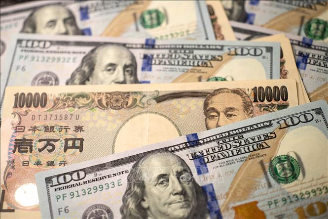 Đồng tiền mệnh giá 10.000 yen Nhật Bản và 100 đô la Mỹ. Ảnh: THX/TTXVN phát