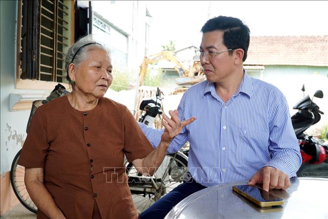 Bí thư Đảng ủy xã Tư Nghĩa Nguyễn Đăng Vinh (phải) hỏi thông tin từ bà Hồ Thị Phó (64 tuổi), cháu dâu ông Lê Tài. Ảnh: Lê Phước Ngọc  