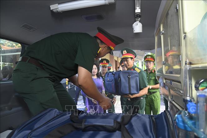 Các mẫu sinh phẩm hài cốt liệt sĩ được đưa ra xe chuyên dụng. Ảnh: Chanh Đa - TTXVN