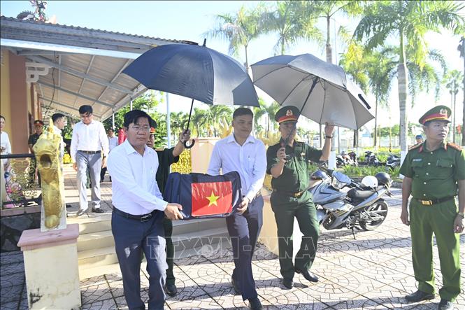 Đại diện lãnh đạo chính quyền địa phương xã Phước Long chuyển các mẫu sinh phẩm hài cốt liệt sĩ đi giám định ADN. Ảnh: Chanh Đa - TTXVN