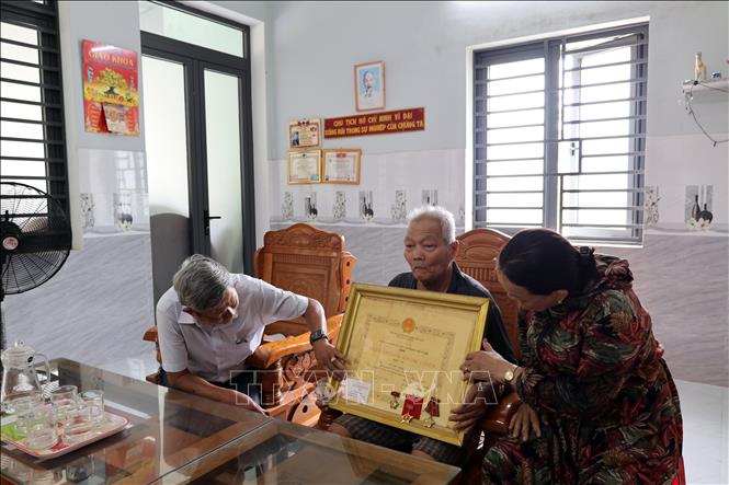 Cán bộ hội đoàn thể cơ sở ở phường Bàn Thạch (Đà Nẵng) đến thăm hỏi, động viên ông Võ Văn Châu là thương bệnh binh bị nhiễm chất độc hóa học da cam, để lại di chứng đến thế hệ thứ hai. Ảnh: Đỗ Trưởng – TTXVN