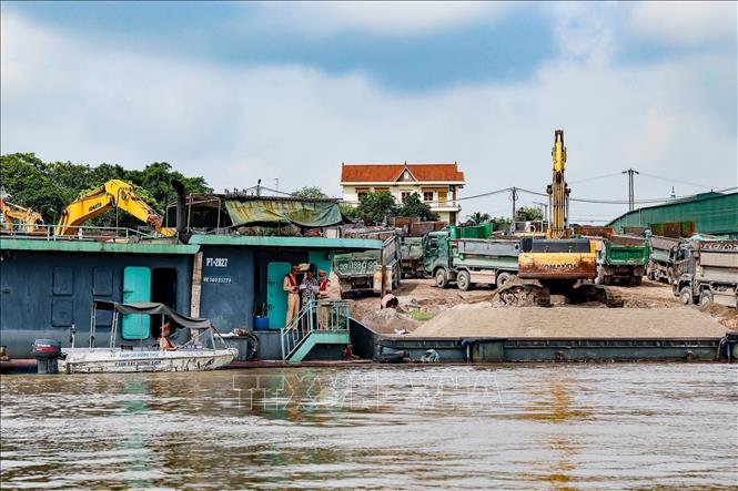 Lực lượng Đội Cảnh sát đường thủy số 2 kiểm tra hoạt động của phương tiện thủy tại một bến tập kết vật liệu xây dựng ven sông Hồng. Ảnh: Trung Nguyên - TTXVN