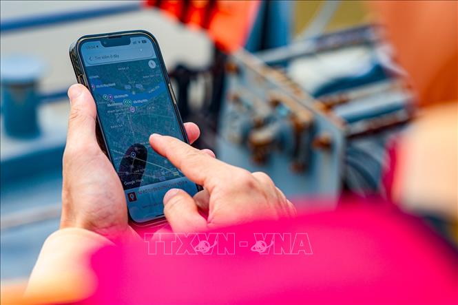 Cán bộ Đội Cảnh sát đường thủy số 2 tra cứu thông tin trên bản đồ đường thủy online trong quá trình thực hiện nhiệm vụ. Ảnh: Trung Nguyên - TTXVN