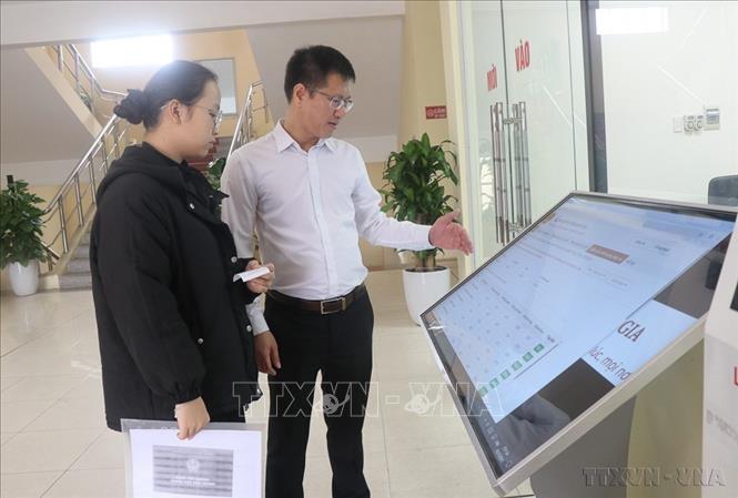  Hướng dẫn người dân phường Tam Sơn, tỉnh Bắc Ninh thực hiện thủ tục hành chính trên môi trường điện tử. Ảnh: Thái Hùng - TTXVN
